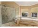 Bright bathroom featuring a glass-enclosed shower and a relaxing soaking tub under a sunny window at 4607 E Rancho Laredo Dr, Cave Creek, AZ 85331