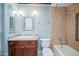 Bathroom boasts a granite countertop with a dark wood cabinet, decorative mirror and shower-tub combination at 4750 N Central Ave # 12H, Phoenix, AZ 85012