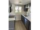 Modern kitchen featuring gray cabinets, stainless steel appliances, quartz countertop, and view to the front entry at 4818 N 73Rd St, Scottsdale, AZ 85251