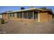 View of the home's sun room with screened windows and a patio, next to the home's red brick exterior at 518 S Racine --, Mesa, AZ 85206