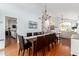 Elegant dining area with wood floors, long table with seating for ten, and modern lighting at 5771 W Gail Dr, Chandler, AZ 85226