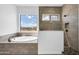 Modern bathroom featuring soaking tub, glass shower, and neutral tile at 6107 E Lone Mountain Rd, Cave Creek, AZ 85331