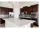 Elegant kitchen featuring dark wood cabinets, stainless steel appliances, granite counters, and a center island at 6107 E Lone Mountain Rd, Cave Creek, AZ 85331