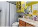 A traditional bathroom offers a sink, vanity, toilet, and shower-tub combination with bright pops of yellow at 6225 W Marconi Ave, Glendale, AZ 85306