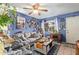 Cozy living room with bright blue walls, comfortable seating, ceiling fan, and natural light, creating a warm atmosphere at 6225 W Marconi Ave, Glendale, AZ 85306