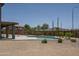 Lush backyard featuring a kidney-shaped pool, desert landscaping, and a covered patio for outdoor enjoyment and entertaining at 6993 S Sharon Ct, Chandler, AZ 85249
