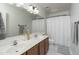 Bright bathroom featuring a double vanity, a large mirror, and a shower/tub with a curtain at 6993 S Sharon Ct, Chandler, AZ 85249