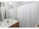 Cozy bathroom featuring a vanity with a single sink, a framed mirror, and a shower with a white curtain at 6993 S Sharon Ct, Chandler, AZ 85249