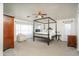 Spacious primary bedroom features a dark four-poster bed, neutral walls and an armchair at 6993 S Sharon Ct, Chandler, AZ 85249