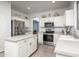 Bright kitchen with island, stainless appliances, white cabinets, and view into the living area at 6993 S Sharon Ct, Chandler, AZ 85249