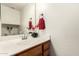 Bathroom vanity with wood cabinets, decorative mirror, and stylish faucet at 702 S Beck Ave, Tempe, AZ 85281