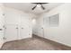 Bedroom with neutral carpet, ceiling fan, window, and several closet options at 702 S Beck Ave, Tempe, AZ 85281