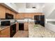 Spacious kitchen with wooden cabinets, granite countertops, and modern black appliances at 702 S Beck Ave, Tempe, AZ 85281