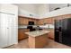 Well-lit kitchen featuring an island, granite countertops, and black appliances at 702 S Beck Ave, Tempe, AZ 85281