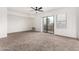 Bright living room featuring neutral carpet, ceiling fan, and sliding door to balcony at 702 S Beck Ave, Tempe, AZ 85281