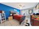 Bright bedroom with a blue accent wall, ceiling fan, and tiled floors at 7132 W Vermont Ave, Glendale, AZ 85303