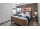 Cozy bedroom with wooden bed frame, a brick accent wall, and a built-in desk at 7315 E Northland Dr # 8, Scottsdale, AZ 85251