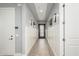 Hallway features wainscoting, wood-look tile, and modern lighting leading to an elegant entryway door at 7518 E Vista Bonita Dr, Scottsdale, AZ 85255