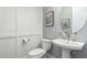 Charming powder room featuring white wainscoting and a modern pedestal sink with circular mirror at 7518 E Vista Bonita Dr, Scottsdale, AZ 85255