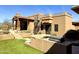 Backyard with synthetic grass, an outdoor kitchen, and a spiral staircase to the rooftop patio at 8386 E Arroyo Seco Rd, Scottsdale, AZ 85266