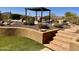 Desert backyard featuring a pergola, pool area, desert landscaping, and travertine pavers at 8386 E Arroyo Seco Rd, Scottsdale, AZ 85266