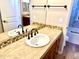 Bright bathroom featuring a vanity with stone countertop, a decorative backsplash and a bronze fixtures at 8386 E Arroyo Seco Rd, Scottsdale, AZ 85266