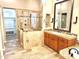 Elegant bathroom with a chandelier, dual sinks, granite countertop, and a large, tiled glass shower at 8386 E Arroyo Seco Rd, Scottsdale, AZ 85266