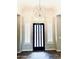 Elegant foyer featuring a modern light fixture, white shutters, and herringbone-patterned wood floors at 8386 E Arroyo Seco Rd, Scottsdale, AZ 85266