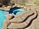 Relaxing hot tub with stone accents, built-in steps, and views of the surrounding desert landscape at 8386 E Arroyo Seco Rd, Scottsdale, AZ 85266