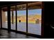 Covered patio with an outdoor grill and desert landscaping, as seen through sliding glass doors at 8386 E Arroyo Seco Rd, Scottsdale, AZ 85266