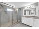 Modern bathroom featuring a glass shower and a double sink vanity with a large mirror at 8637 E Jackrabbit Rd, Scottsdale, AZ 85250