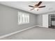 Light and airy bedroom with neutral carpet, ceiling fan and a large window with bright white shutters at 8637 E Jackrabbit Rd, Scottsdale, AZ 85250