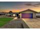 Charming single-story home featuring a bright purple/blue garage door and well-manicured lawn at sunset at 8637 E Jackrabbit Rd, Scottsdale, AZ 85250