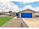 Charming single-story home featuring a bright blue garage door and well-manicured lawn at 8637 E Jackrabbit Rd, Scottsdale, AZ 85250