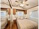 This bedroom features coordinated bedding, wood trim, a ceiling fan, and a mirrored closet at 864 S Motherlode Dr, Apache Junction, AZ 85119