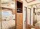 Bedroom with mirrored closet doors and wood cabinets and trim accents at 864 S Motherlode Dr, Apache Junction, AZ 85119