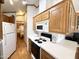 A kitchen area featuring a white refrigerator, black stovetop, and wood cabinets at 864 S Motherlode Dr, Apache Junction, AZ 85119