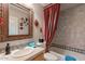 Stylish bathroom featuring an ornate mirror, patterned shower curtain, and tiled walls at 9431 N Summer Hill Blvd, Fountain Hills, AZ 85268