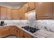 Kitchen with granite countertops, a cooktop, and wood cabinetry providing a stylish, functional space at 9431 N Summer Hill Blvd, Fountain Hills, AZ 85268