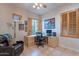 Well-lit home office with a large desk, wood shutters, tile flooring, and brick-accented walls at 9431 N Summer Hill Blvd, Fountain Hills, AZ 85268