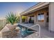 Backyard pool featuring desert landscaping, a stone accent wall, and a covered patio at 9431 N Summer Hill Blvd, Fountain Hills, AZ 85268