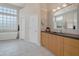 Spacious bathroom featuring tile floors, soaker tub, and double doors at 9727 E Presidio Rd, Scottsdale, AZ 85260