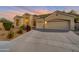 Well-maintained home exterior featuring a three-car garage, desert landscaping, and a paved driveway at 9727 E Presidio Rd, Scottsdale, AZ 85260