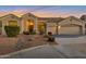 Charming single-story home with three-car garage, desert landscaping, and a warm, inviting ambiance at twilight at 9727 E Presidio Rd, Scottsdale, AZ 85260