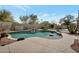 Backyard pool area featuring a rock waterfall and a built-in grill, perfect for outdoor entertaining at 9727 E Presidio Rd, Scottsdale, AZ 85260