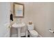 Elegant powder room features a pedestal sink, decorative mirror, and convenient toilet paper holder for guests at 9727 E Presidio Rd, Scottsdale, AZ 85260