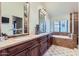 Bathroom featuring a double vanity, granite countertops, and neutral tiled flooring at 9803 N 100Th Pl, Scottsdale, AZ 85258