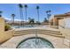 Hot tub overlooking community pool surrounded by palm trees under blue skies at 9803 N 100Th Pl, Scottsdale, AZ 85258