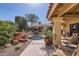 Charming patio with water feature, table, chairs, and lush desert landscaping at 9803 N 100Th Pl, Scottsdale, AZ 85258