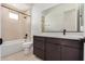 Well-lit bathroom with a combo tub/shower, dark fixtures, and a dark wood vanity at 10308 E Utah Ave, Mesa, AZ 85212